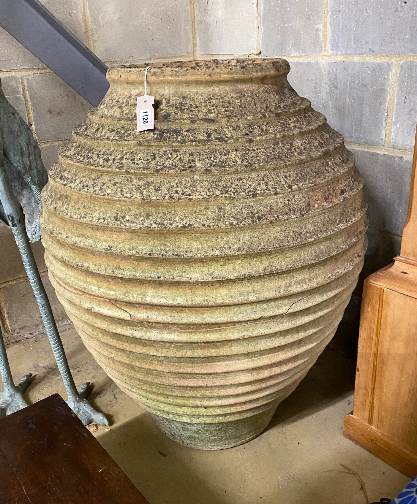 A large Grecian style circular earthenware oil jar (broken in two), height 84cm
